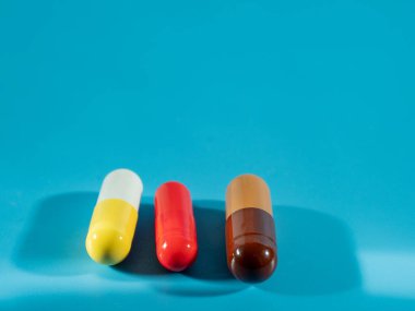 Mavi arka planda çok renkli tıbbi kapsüller.