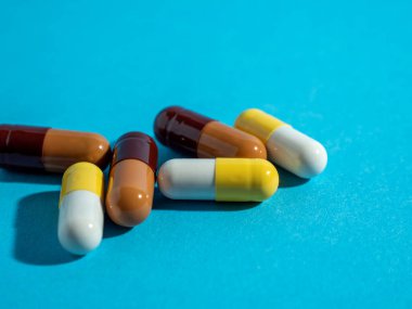 Mavi arka planda çok renkli tıbbi kapsüller.