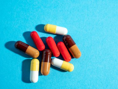 Mavi arka planda çok renkli tıbbi kapsüller.