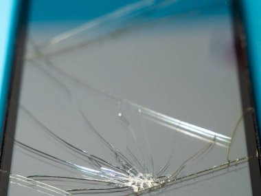 Bozuk ekranlı siyah akıllı telefon ve serviste mavi bir masanın üzerinde ceset..