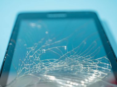 Bozuk ekranlı siyah akıllı telefon ve serviste mavi bir masanın üzerinde ceset..