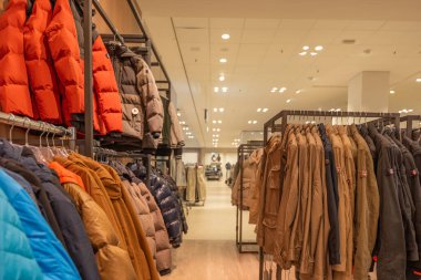Almanya 7 Ekim 2025. Kışlık ceketler askıda. Rengarenk kışlık ceketler bir mağazanın raflarına dizilmişti. Ekrana turuncu, kahverengi ve gri ceketler hakim..