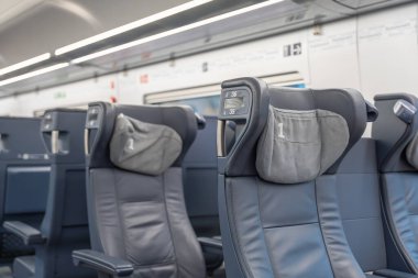 Birinci sınıf koltuğun detaylı görüntüsü. Üzerinde 1 yazan gri başlık kapağı var. Yolcu konforu için modern deri tasarımı.