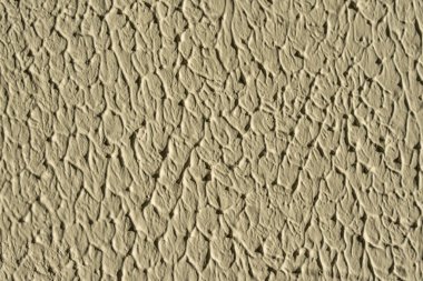 Düzensiz kabataslak yüzey desenli bej duvar dokusuna yakın plan. Malzeme detaylarının soyut makrosu.