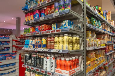 Almanya Sylt 27.10.2025. Protein ve beslenme içecekleri. Modern ambalajlarda enerji içecekleri ve protein karışımlarıyla rafları göster. Popüler beslenme markaları ve renkli şişeler koridora hakim..