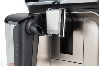 Süt köpürme borusunun ve paslanmaz bir yüzeydeki kahve hortumunun yakın plan ayrıntıları. Temiz tasarım hassasiyet ve kalite işçiliği sergiler.