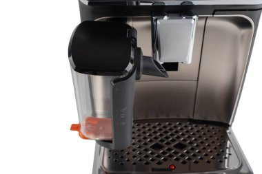 Modern bir espresso makinesinin yakın çekimi beyaz arka planda süt köpürtücü eklentisi. Tasarımda profesyonel bir bitiriş için parlak siyah ve krom ayrıntılar yer alıyor..