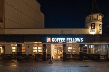 Almanya Sylt 27 Ekim 2025. Kahve Dostları Kafe 'nin dışı gece aydınlandı. Sıcak ışıklar ve boş sandalyeler rahat bir atmosfer yaratır..