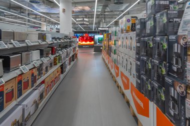 Almanya 31 Ekim 2025. Parlak ışıklı bir mağazada mutfak aletleri ve kutularla dolu uzun bir koridor. Modern tasarım düzen ve teknolojiyi vurgular..