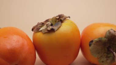 Üç olgun hurma yakın çekim sırasında sıkıca gruplandırılır. Video, zengin organik dokular için gövdelerinde ve derilerinde duruyor..