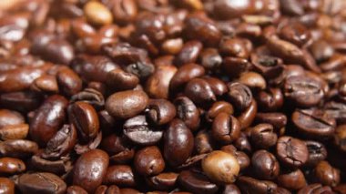 Çerçeveyi dolduran aşırı yakın plan kavrulmuş kahve çekirdekleri. Her fasulye yüzeyi ve çatlak keskin bir şekilde görülebilir..