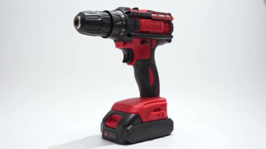 Batarya kablosuz matkap sürücüsü beyaz arka planda dönüyor. Tam görünüm, tutuş, pil ve bit tutucuyu gösterir..