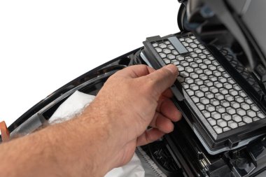 El, yenisi için açık bir teneke kutudan bal peteği vakum filtresi çeker. Yakın çekim bakım sahnesi beyaz arkaplanda izole edildi.