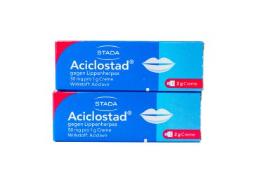 Acicloostad aciclovir krem kutuları istiflenmiş, beyaza izole edilmiş. Uçuk ve uçuk tedavisi teması için eczane çantası fotoğrafı.