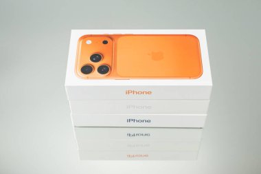 Almanya 25 Aralık 2025. Orange iPhone 17 Pro kutusu üst kattan istiflenmiş paketleme üzerinde fotoğraflandı. Kalın renk en az arkaplan ve temiz perakende tasarımı ile çelişir.