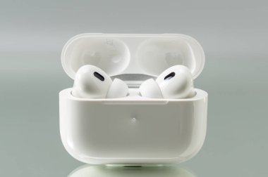 Yukarıdan çekilen kablosuz kulaklıklarla şarj et. Kompozisyon simetri ve fonksiyonel tasarım üzerine odaklanır.