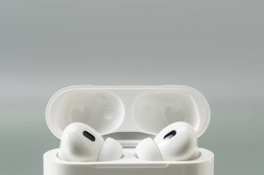 Açık bir şarj kutusuna yerleştirilmiş kablosuz kulaklıkları kapatın. Yumuşak gölgeler ve nötr tonlar sakin, modern ürün havası yaratır..