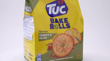 Almanya 28 Aralık 2025. TUC Bake Rolls Tomate ve Olive paketinin açılı görüntüsü derinliği ve yapıyı göstermek için düzgün döner. Beyaz arka planda profesyonel dönen atıştırmalık ambalaj çekimi.