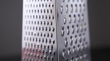 Paslanmaz çelik bir rendeleyicinin dönüşümlü görüntüsü birden fazla ızgara yüzeyi ve parlatılmış metal kaplamayı gösteriyor. Yavaş dönüş işlevselliği, simetriyi ve profesyonel mutfak kalitesini vurgular.