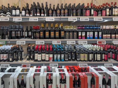 Almanya 29 Aralık 2025. Süpermarket raflarında görülebilir fiyatlarla hazırlanmış geniş bir şarap şişesi seçimi. Düzenli perakende gösterimi çeşitli kırmızı şarap ve markaları gösteriyor.