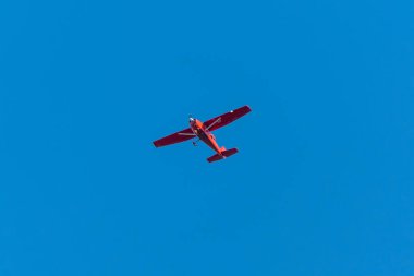 Blue Sky 'daki Kızıl Uçak. Açık mavi gökyüzüne karşı uçan küçük kırmızı bir uçak ve bolca kopya alanı var. Asgari havacılık görüntüsü özgürlüğü, seyahati ve uçuşu simgeliyor.