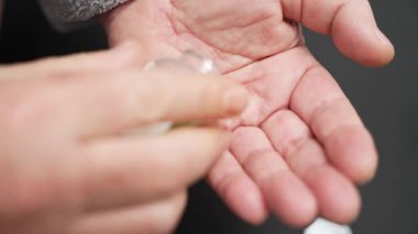 Şişeden tek bir hap alıyor. İlaç şişesinden alınan tek bir hapı tutan bir elin yakın çekimi. Tıbbi tedavi ve sağlık hizmeti kavramı.