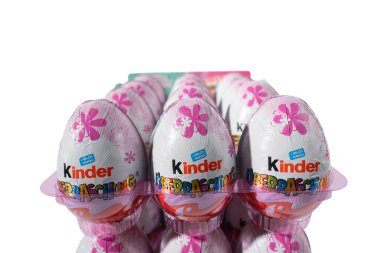 Önünde pembe çiçekler olan bir kutu Kinder yumurtası. Kutuda 12 yumurta var.