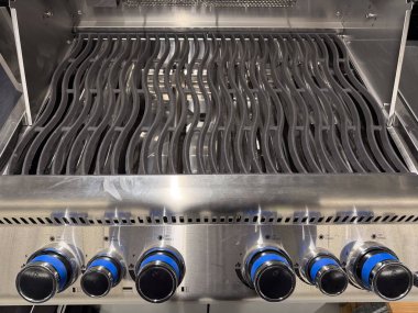 Izgaralı bir ızgara. Izgara gümüşten ve üstünde mavi bir düğmesi var.