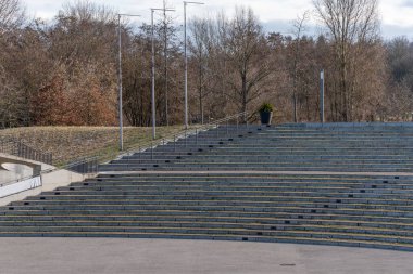 Stadyum boş ve ortasında büyük bir saksı bitkisi var. Bitki bir bankın üzerine yerleştirilir ve birkaç adımla çevrilidir. Stadyum geniş, açık bir alan ve bir sürü oturma yeri var.