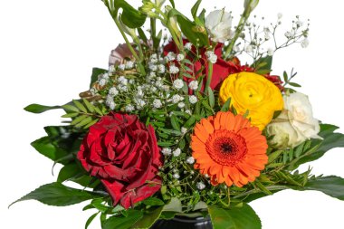 Kırmızı turuncu gerbera ve sarı ranunculus içeren canlı bir çiçek buketinin detaylı bir görüntüsü. Taze yeşillik ve narin beyaz çiçekler renkli çiçeklerin etrafını sarar..