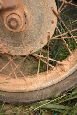Dikey Cu çamurlu jant ve çim üzerinde hafif motosiklet lastik