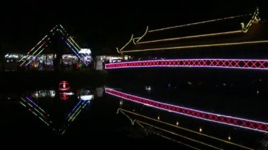 Küçük bir nehir geceleri Asya'da kapsayan parlak neon yaya köprüsü görünümünü