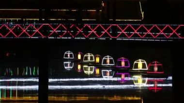 Bir nehir geceleri Asya'da kapsayan orta görünümü neon yaya köprüsü