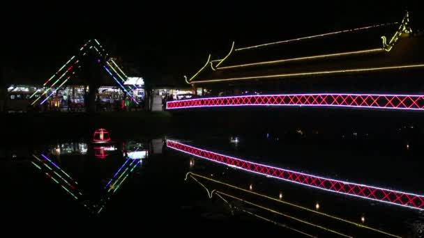 Vista de néon brilhante passarela abrangendo um pequeno rio à noite na Ásia — Vídeo de Stock