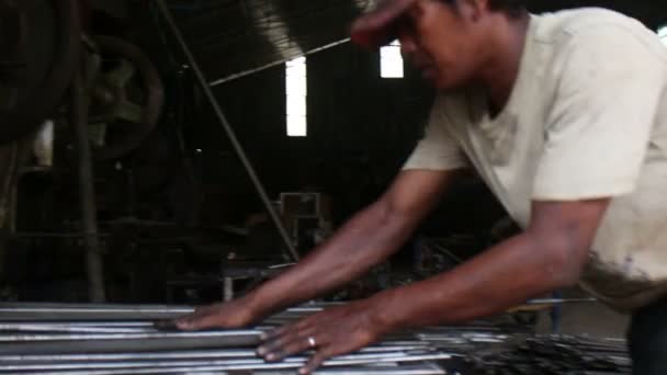 BATTAMBANG, CAMBODIE - 3 avril 2016 : Atelier de métallurgie - Un ouvrier rassemble des tiges vierges métalliques pour l'estampage — Video