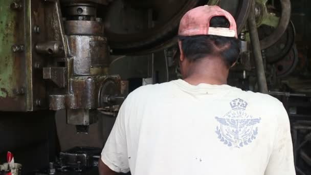 BATTAMBANG, CAMBODIA - 3 de abril de 2016: Metalworking Machine Shop - MCU of worker tending a heavy stamping press — Vídeos de Stock