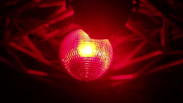 Sfera discoteca con luce rossa che brilla contro la sua superficie specchiata — Video Stock