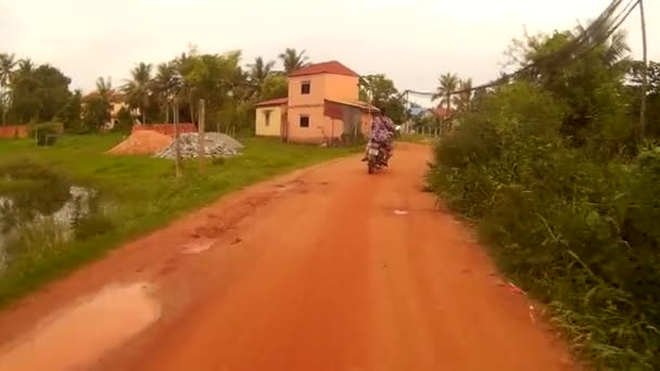 SIEM REAP, CAMBODIA - CIRCA JULY 2016: Action cam POV taking a turn down small dirt road in Asia with passing motos — Stock Video