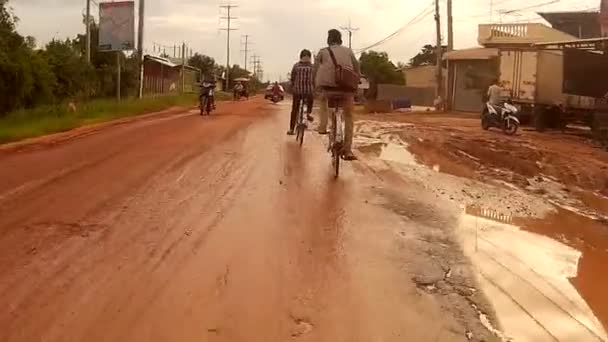 Siem Reap, Kambodža - cca červenec 2016: Action cam Pov koni zablácený, deštivé cestě v Asii, kolem cyklisty — Stock video