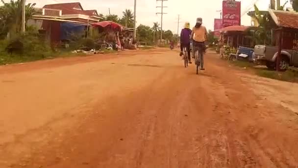 SIEM REAP, CAMBOYA - CIRCA JULIO 2016: Camara de acción POV recorriendo una carretera semipavimentada en el Asia rural con tráfico — Vídeos de Stock