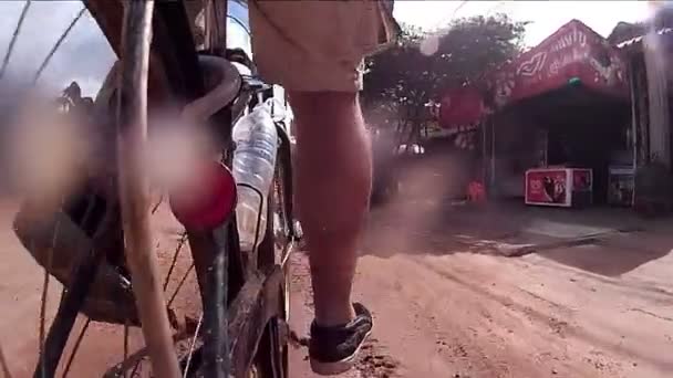 SIEM REAP, CAMBODIA - CIRCA JULIO 2016: 60 fps cámara lenta Vista trasera cámara de acción POV Asia ciclismo - charco en la carretera — Vídeo de stock