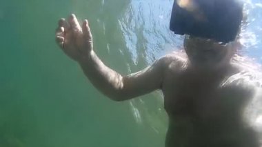 Orta düşük açılı gerçeküstü görünümü adamla Vr kulaklık okyanus dalgalarının altında
