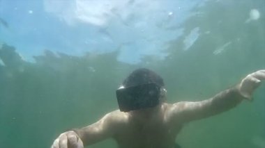 Vr kulaklık ile geniş çekim adam derin okyanus, yaymak silah altında iner