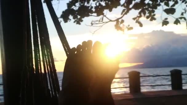 एमसीयू पैर हैमॉक में देखे गए, पैरों के माध्यम से चमकते सूरज के साथ — स्टॉक वीडियो