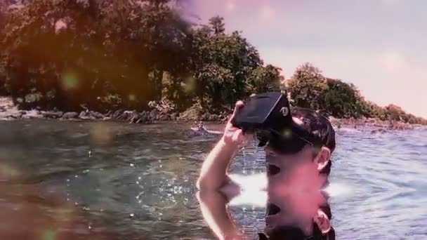 Hombre de visión media se pone auriculares de realidad virtual VR en laguna tropical (FX añadido ) — Vídeo de stock