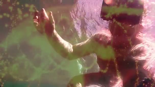 Faible angle moyen gros plan homme descendant sous les vagues de l'océan portant un casque de réalité virtuelle VR. La couleur, la texture et d'autres effets ont été ajoutés pour améliorer l'expérience immersive (prise de vue à 60 ips) / / Un d'une série de VR, AR, et virtuel et augm 