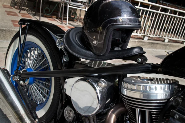 Black vintage style motorcycle with chrome and black helmet — Stock Photo, Image