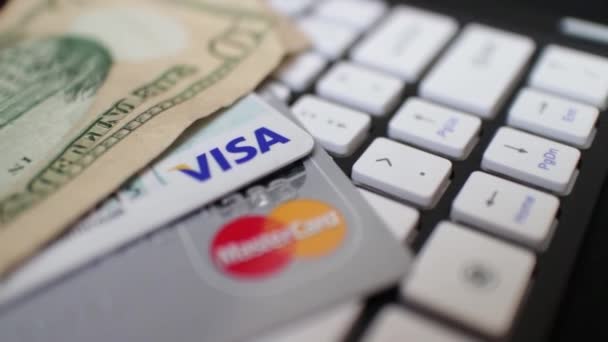 ECOMMERCE - Cámara se mueve a través de tarjetas de crédito y dinero en efectivo en el teclado — Vídeo de stock