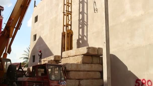 СИАМ-РИП, КАМБОДИЯ - CIRCA JULY 2015: Кран поднимает длинную бетонную кучу и помещает в раму — стоковое видео