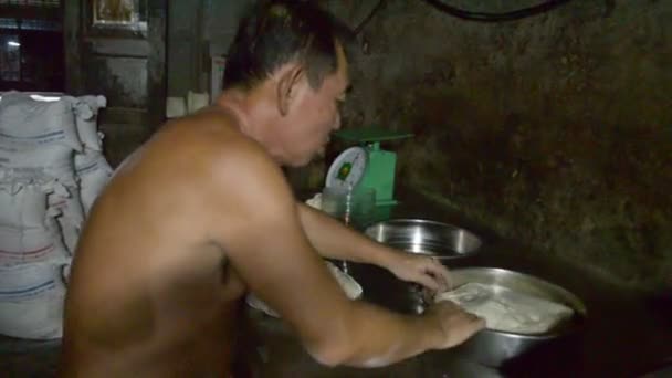 Kampot, Cambodja - Circa November 2013: Medium shot Aziatische baker slapping deeg in een pan — Stockvideo